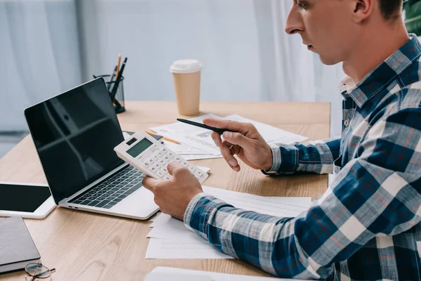 Visão parcial do empresário com calculadora trabalhando no local de trabalho com documentos e laptop — Fotografia de Stock