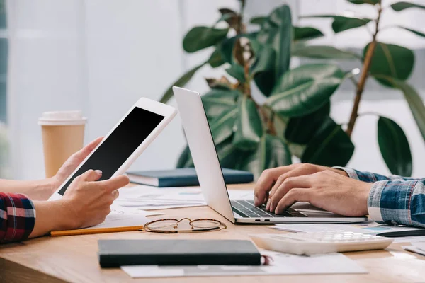 Visione parziale di imprenditori con dispositivi digitali che lavorano sul posto di lavoro con documenti — Foto stock