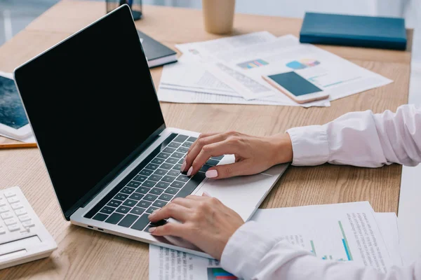 Teilbild einer Geschäftsfrau, die am Laptop mit leerem Bildschirm am Arbeitsplatz im Büro arbeitet — Stockfoto