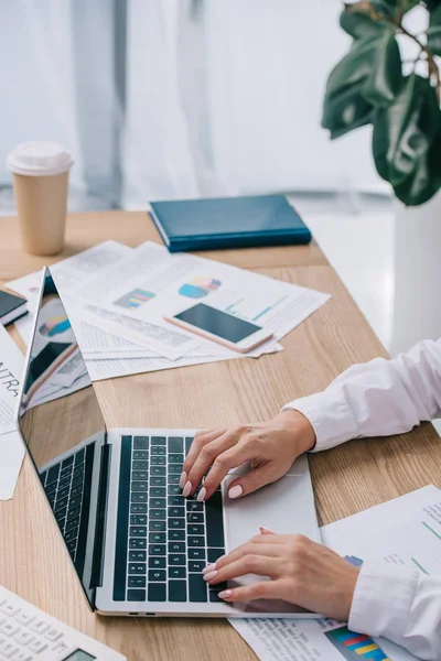 Vue partielle de la femme d'affaires travaillant sur un ordinateur portable avec écran blanc au travail dans le bureau — Photo de stock