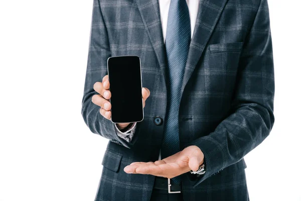 Обрезанный снимок бизнесмена в костюме, показывающий смартфон с пустым экраном, изолированным на белом — стоковое фото