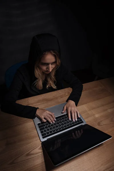 Frau in schwarzem Kapuzenpulli mit Laptop, Cyber-Sicherheitskonzept — Stockfoto