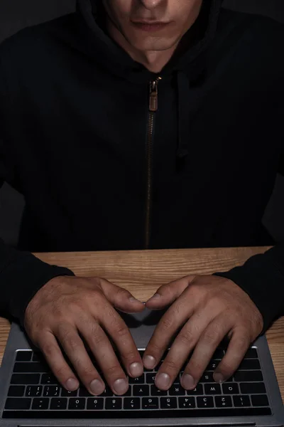Teilbild eines Hackers im schwarzen Kapuzenpulli mit Laptop, Sicherheitskonzept Cuber — Stockfoto