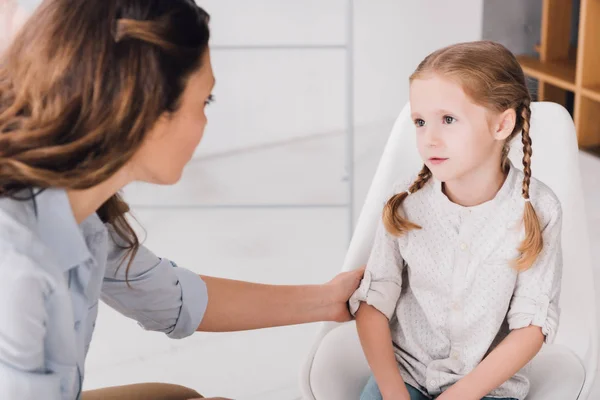 Close-up shot of adult psychologist talking with little patient in office — Stock Photo