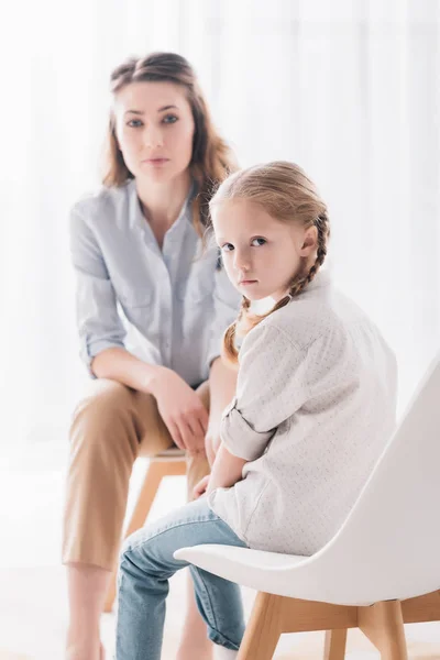 Adult psychologist and depressed little child looking at camera in office — Stock Photo