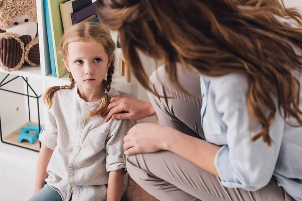 Female psychologist supporting depressed child while she sitting on floor — Stock Photo