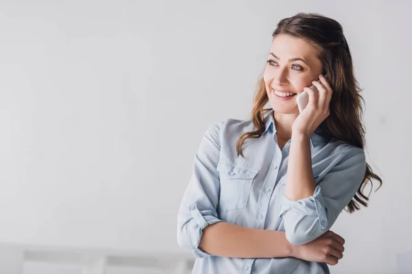 Retrato de cerca de la mujer adulta sonriente hablando por teléfono y mirando hacia otro lado - foto de stock