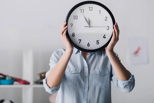 Portrait en gros plan de la femme couvrant le visage avec horloge — Photo de stock