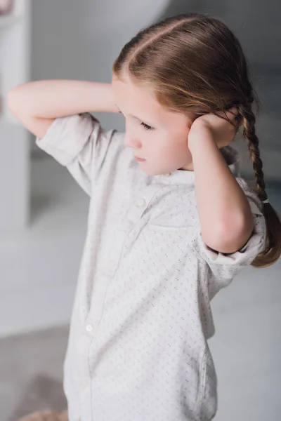 Petit enfant déprimé couvrant les oreilles avec les mains — Photo de stock