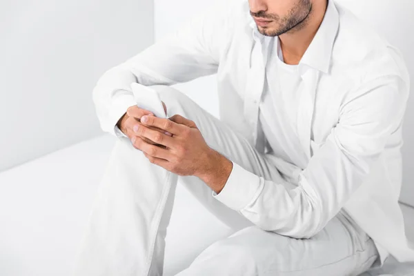 Close up of adult man sitting on floor and using smartphone — Stock Photo