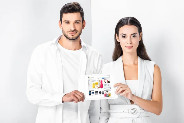 Smiling adult couple showing ebay app on digital tablet screen — Stock Photo