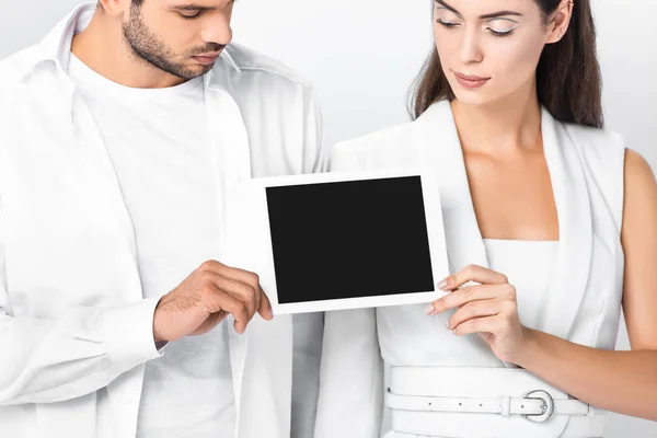 Gros plan du couple adulte en blanc total montrant écran vierge sur écran tablette numérique isolé sur blanc — Photo de stock
