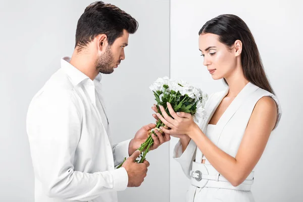 Close up of adult woman gently holding bouquet with man — Stock Photo