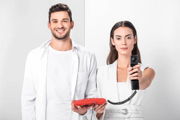 Adult couple in total white holding vintage red telephone handset — Stock Photo