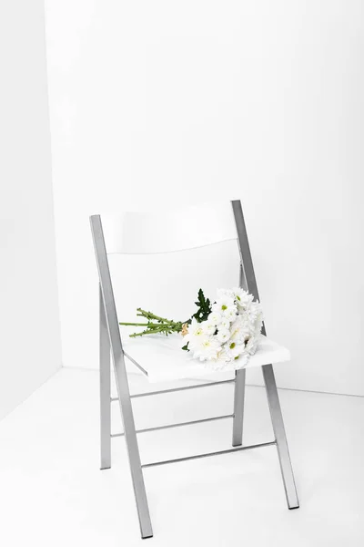 Bouquet of white flowers on chair with copy space — Stock Photo