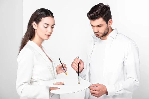 Adult artists in total white with drawing equipment — Stock Photo