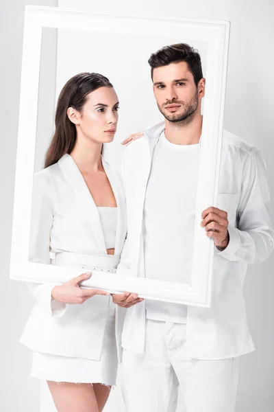 Adult couple in total white posing with frame — Stock Photo