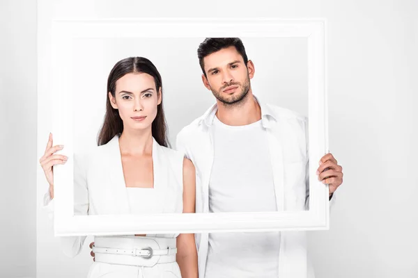 Adult couple in total white posing with frame — Stock Photo