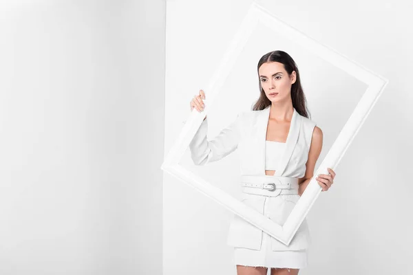 Bella donna in total white holding cornice bianca — Foto stock