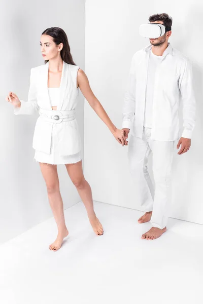 Mujer descalza caminando con el hombre en auriculares de realidad virtual - foto de stock