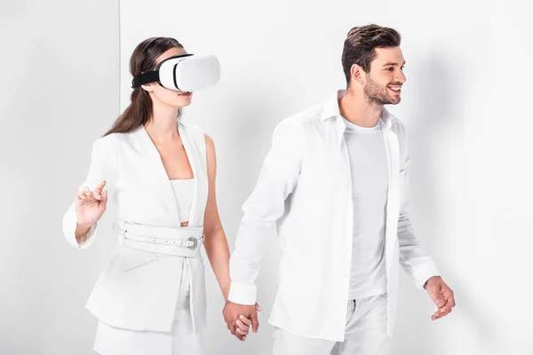 Взрослый мужчина, гуляющий с женщиной в наушниках виртуальной реальности — стоковое фото