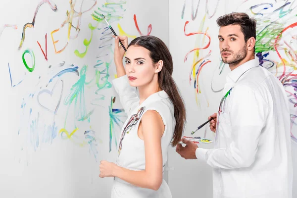 Gros plan du couple en dessin blanc total avec des peintures sur le mur — Photo de stock