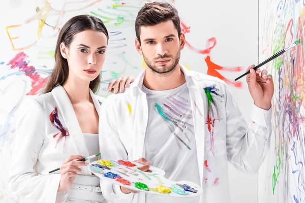 Tiro de moda de par em desenho branco total com pinturas na parede — Fotografia de Stock