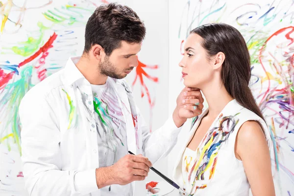 Couple doux adulte avec équipement de dessin contre mur peint — Photo de stock
