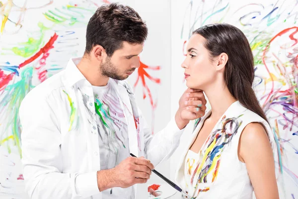 Casal gentil adulto com equipamento de desenho contra parede pintada — Fotografia de Stock