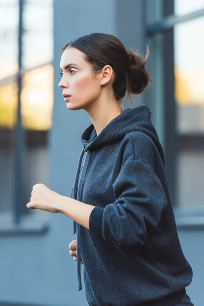 Primer plano de la atractiva deportista adulta corriendo en ropa deportiva - foto de stock