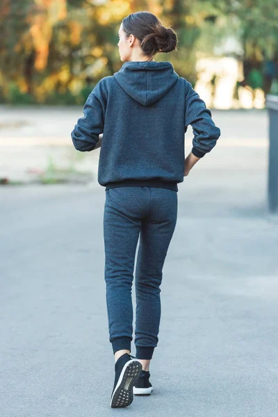 Back view of active adult sportswoman jogging in sportswear — Stock Photo