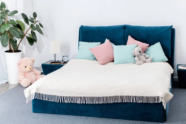 Интерьер спальни с розовыми и голубыми подушками и плюшевыми мишками — стоковое фото
