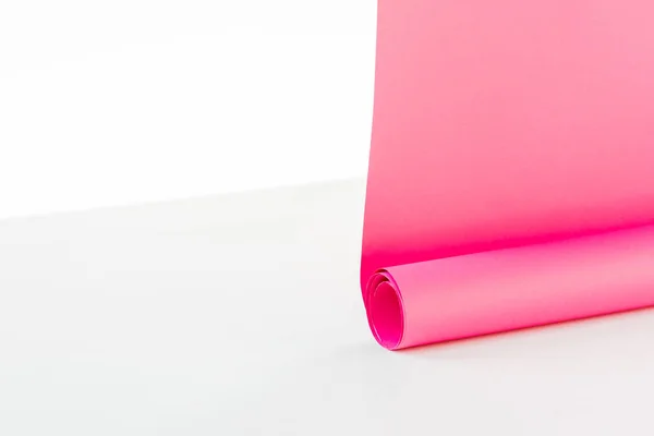 Close up of bright rolled out pink paper hangings on white background — Stock Photo