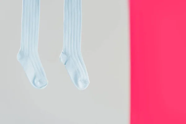 Pair of blue cotton socks on grey and pink background — Stock Photo