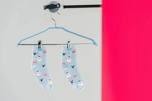 Par de calcetines de algodón azul con patrón de invierno sobre fondo gris y rosa - foto de stock