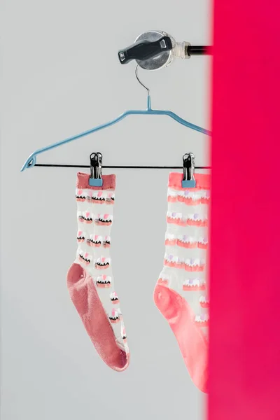 Pair of pink socks with cake pattern on hanger — Stock Photo