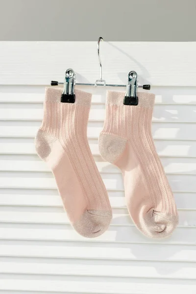 Close up of pink socks hanging on white room divider — Stock Photo