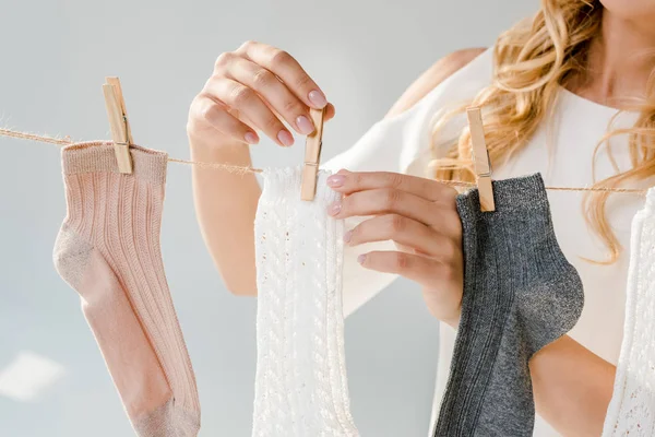 Nahaufnahme einer Frau, die Socken mit Wäscheklammern auf Wäscheleine legt — Stockfoto