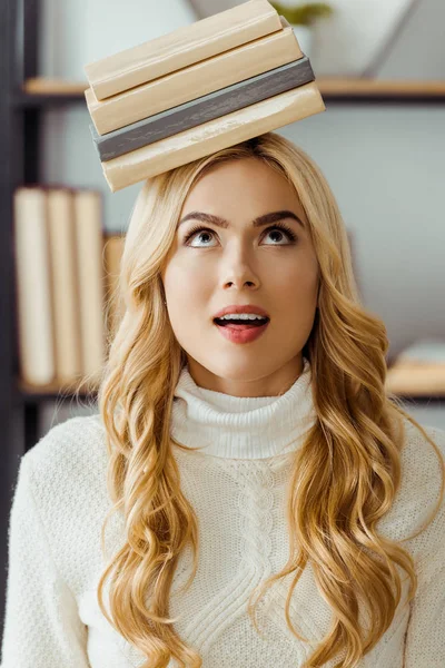 Primo piano di donna divertente con libri sulla testa — Foto stock