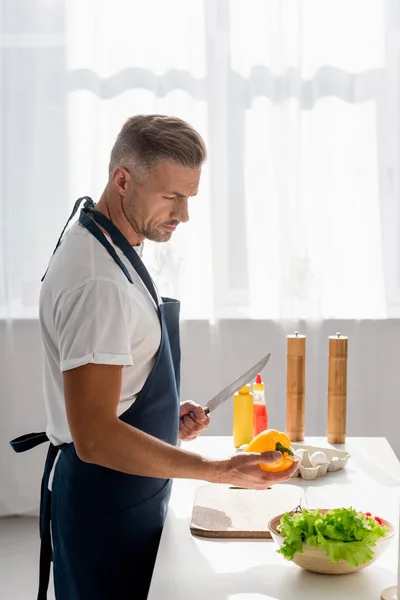 Bonito homem preparando salada em casa — Fotografia de Stock