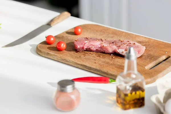 Bife delicioso na tábua de corte com ingredientes — Fotografia de Stock