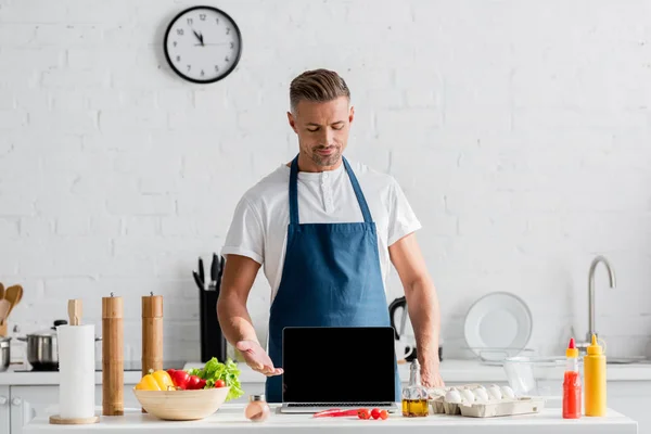 Adult man with black screen on opened laptop standing at kitchen — Stock Photo