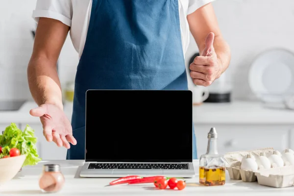 Vista ritagliata dell'uomo con i pollici in su e laptop con schermo nero — Foto stock