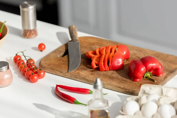 Primer plano de pimienta picada con cuchillo en la tabla de cortar - foto de stock