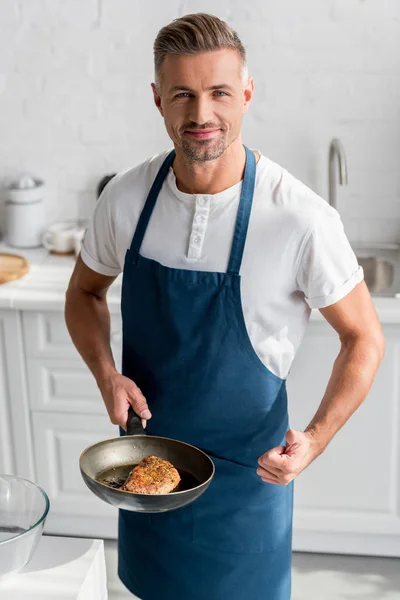 Hombre adulto mostrando los pulgares hacia arriba con filete en la sartén - foto de stock