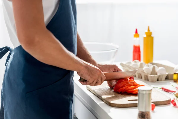 Partial view of man cutting bell pepper for salad — Stock Photo