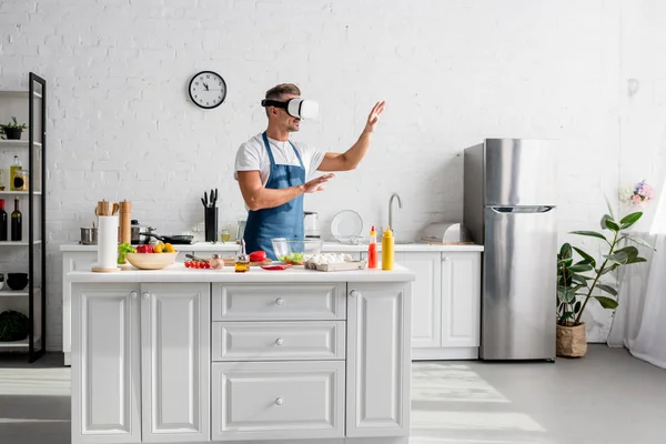 Adult cooker in virtual reality headset standing at kitchen — Stock Photo