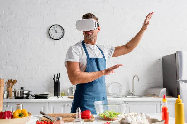 Man in virtual reality headset gesturing at kitchen — Stock Photo