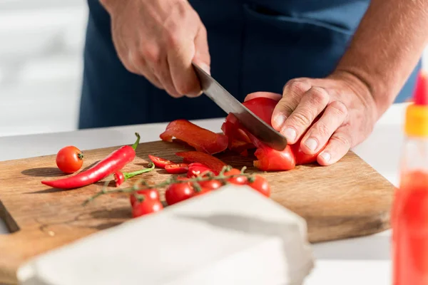 Close up view of male hands cutting chili peppers on chopping board — Stock Photo