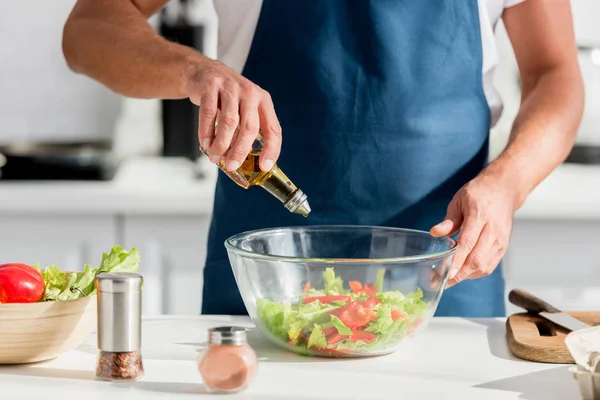 Partial view of male hands adding oil in salad — Stock Photo